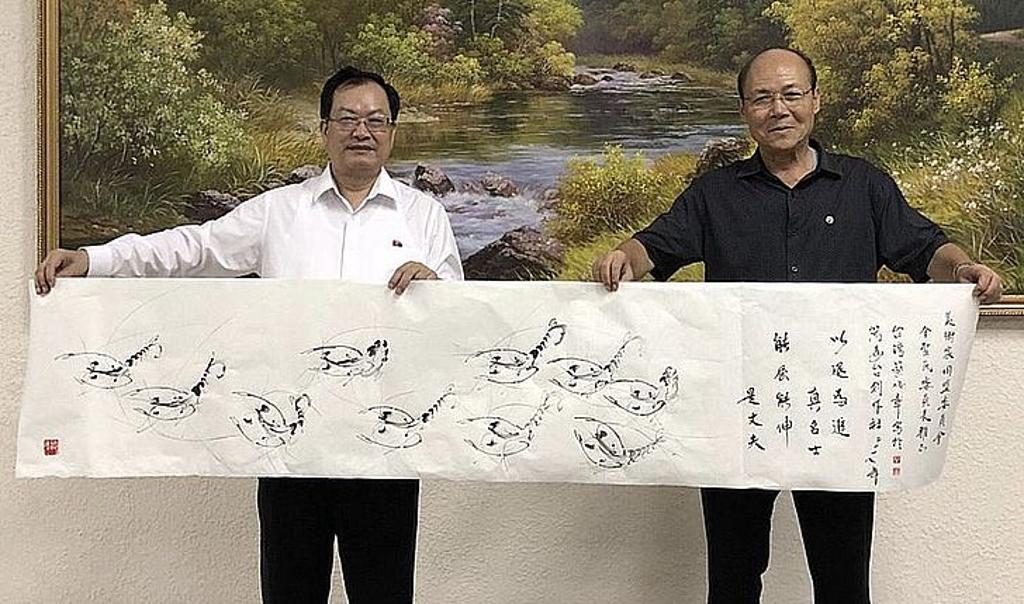 台灣首位公開至朝鮮交流的藝術家──蔡俊章博士（左）現場揮毫創作，致贈萬壽台創作社副社長、美術家同盟委員會委員長金聖民。