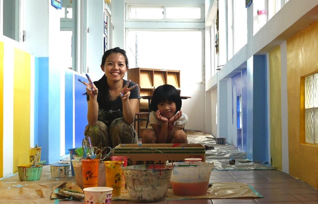 王惠苹彩繪學校牆面時與小朋友一起工作的畫面。圖:勞動力發展署桃竹苗分署提供