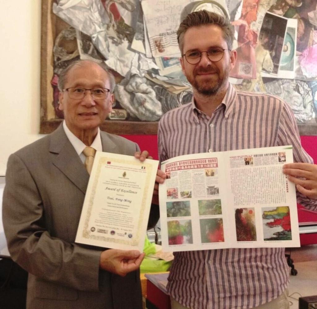 意大利波隆那文化局長Mr.Matteo Lenore（右）頒發榮譽證書予台灣藝術大師蔡豐名（左），蔡豐名則回贈藝術專刊予Mr.Matteo Lenore。圖／蔡豐名提供