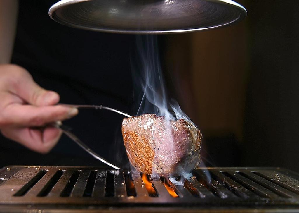 「塊燒」要不停翻動，使其受熱平均，且要經讓牛肉靜置，同時還要不時以烤肉夾按壓牛肉測試生熟程度。圖／姚舜