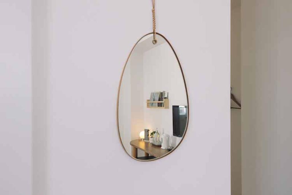 房間內鏡子採鵝卵石造型（左圖）；燈飾則使用花蓮當地文創品牌Kamaro’an的浪草燈，房間的圓潤感油然而生（右圖）。圖／奧丁丁提供