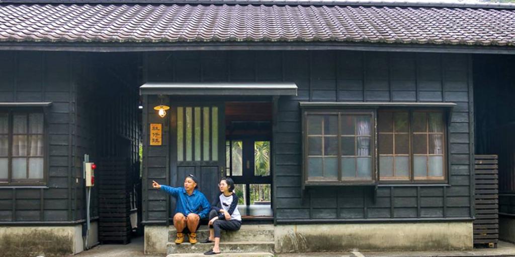 日式復古的一排宿舍被遠方山景與翠綠草皮綠意包圍，就像回到鄉下的家。圖／行遍天下提供