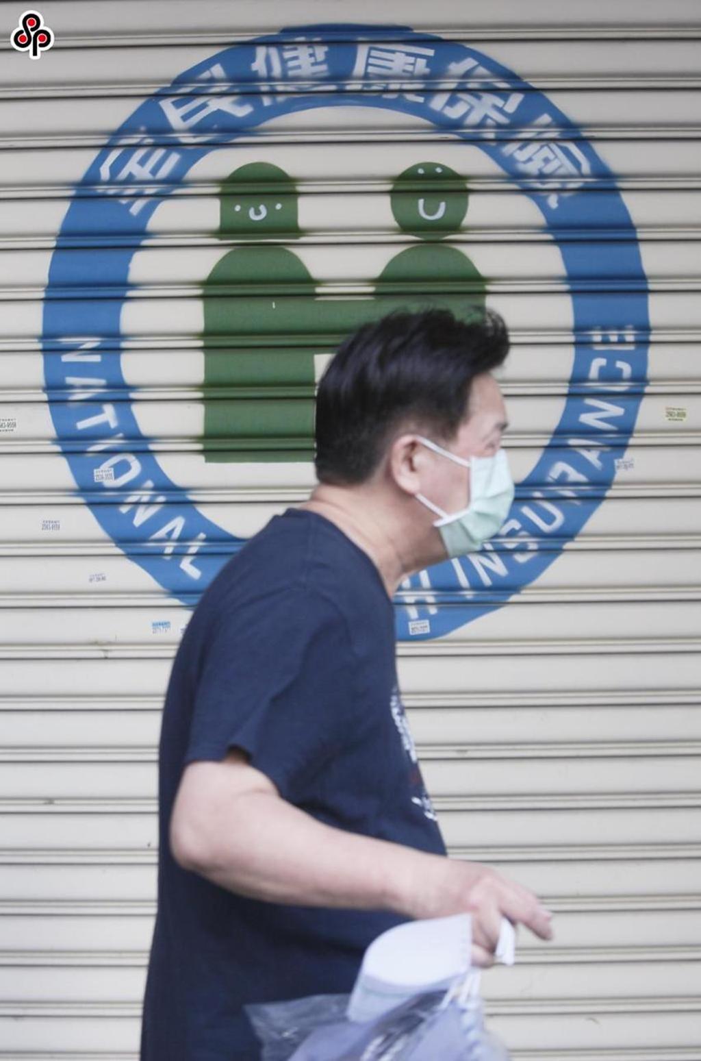 一位民眾經過健保署台北業務組。圖／本報系資料照
