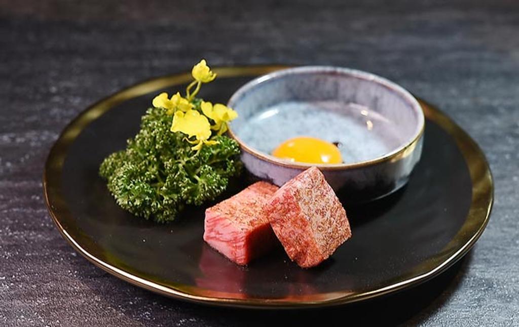 〈日本和牛頂級金塊燒〉會附蛋黃呈盤上桌，牛肉烤熟可以沾附蛋液入口。圖／姚舜