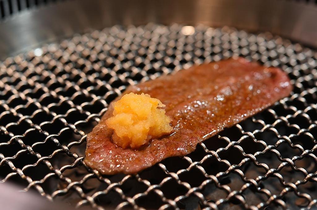在〈燒肉擔當〉燒烤〈日本和牛板腱姿切〉，服務人員會將牛肉捲入柑橘風味蘿蔔泥，可去化和牛的油膩感。圖／姚舜