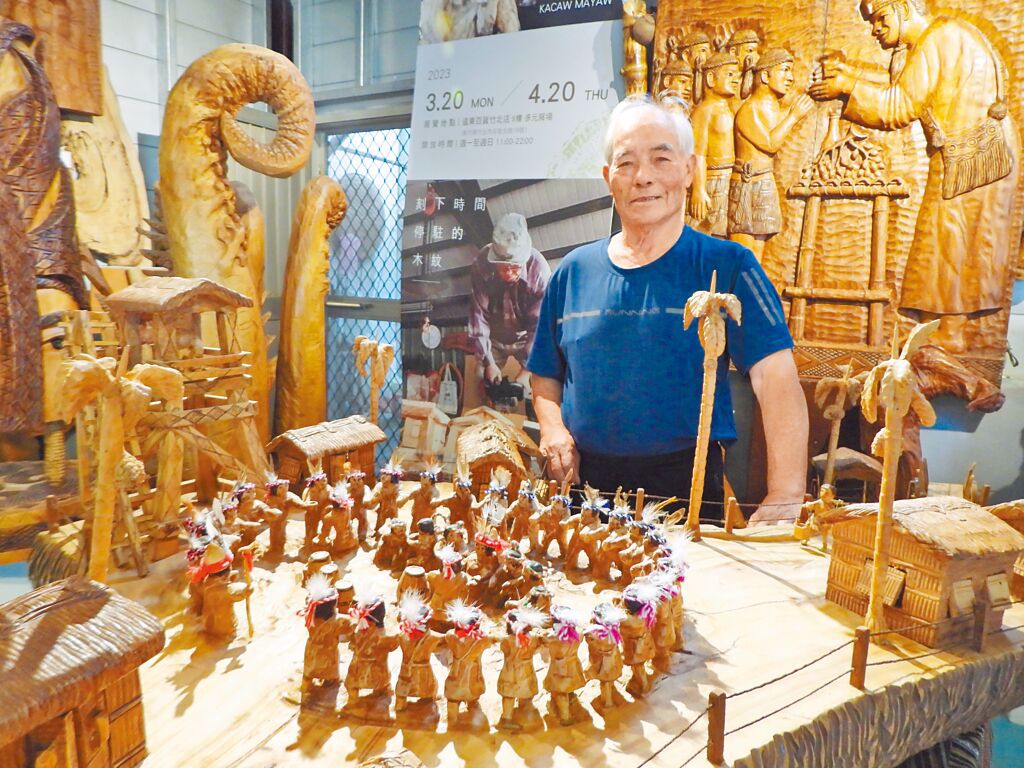 曾獲原住民族工藝薪傳獎的木雕工藝師胡銀祿（卡兆‧馬耀）與其最引以為傲的作品《重建》。圖／羅亦晽攝