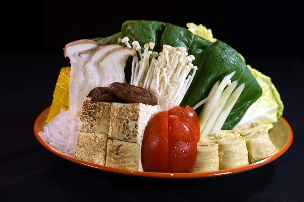 〈食令．SHABU〉大直店蔬菜盤內有生豆皮、香菇、大蔥、大白菜、高麗菜、小松菜、日本玉米、杏鮑菇，以及蒟蒻絲和金針菇。圖／姚舜