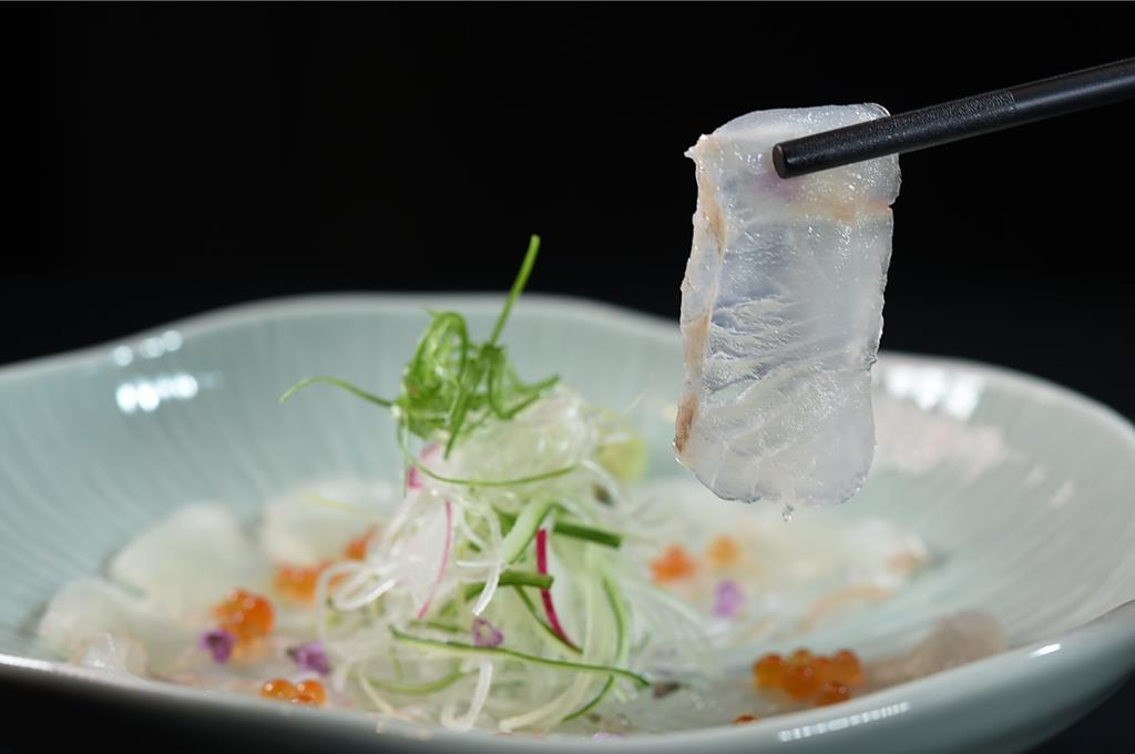 〈食令．SHABU〉雙人鍋物套餐前菜〈比目魚刺身〉，片薄的比目魚生魚片搭配鮭魚卵一起呈現。圖／姚舜