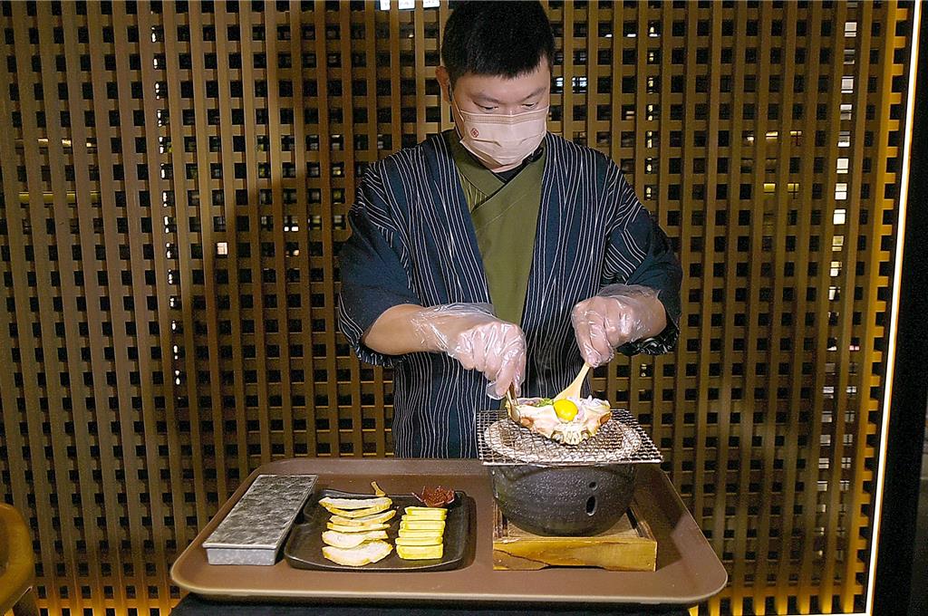 〈旬嚐〉的〈松葉蟹甲羅燒〉，是採桌邊服務由專人在客人面前料理。圖／姚舜