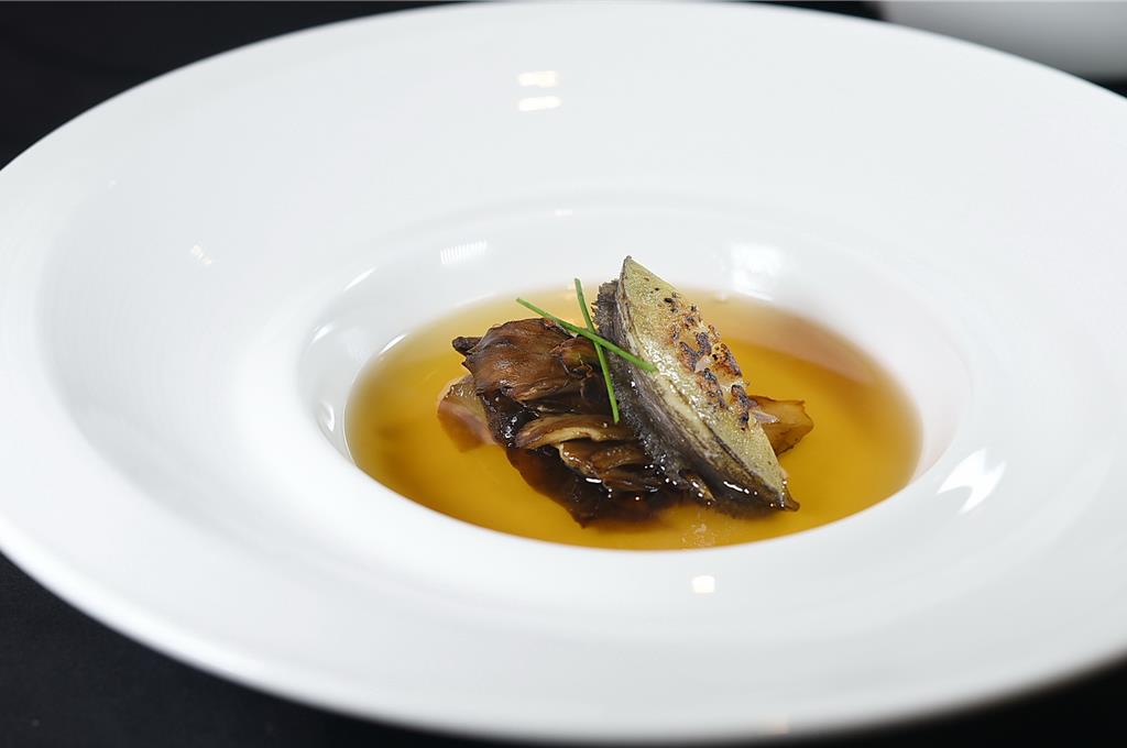 〈上湯煨鮑魚海參〉是以粵菜方式以老母雞、火腿熬上湯，再以法菜方式將湯「澄清」，鮑魚與海參分開煨煮賦味再入湯。圖／姚舜