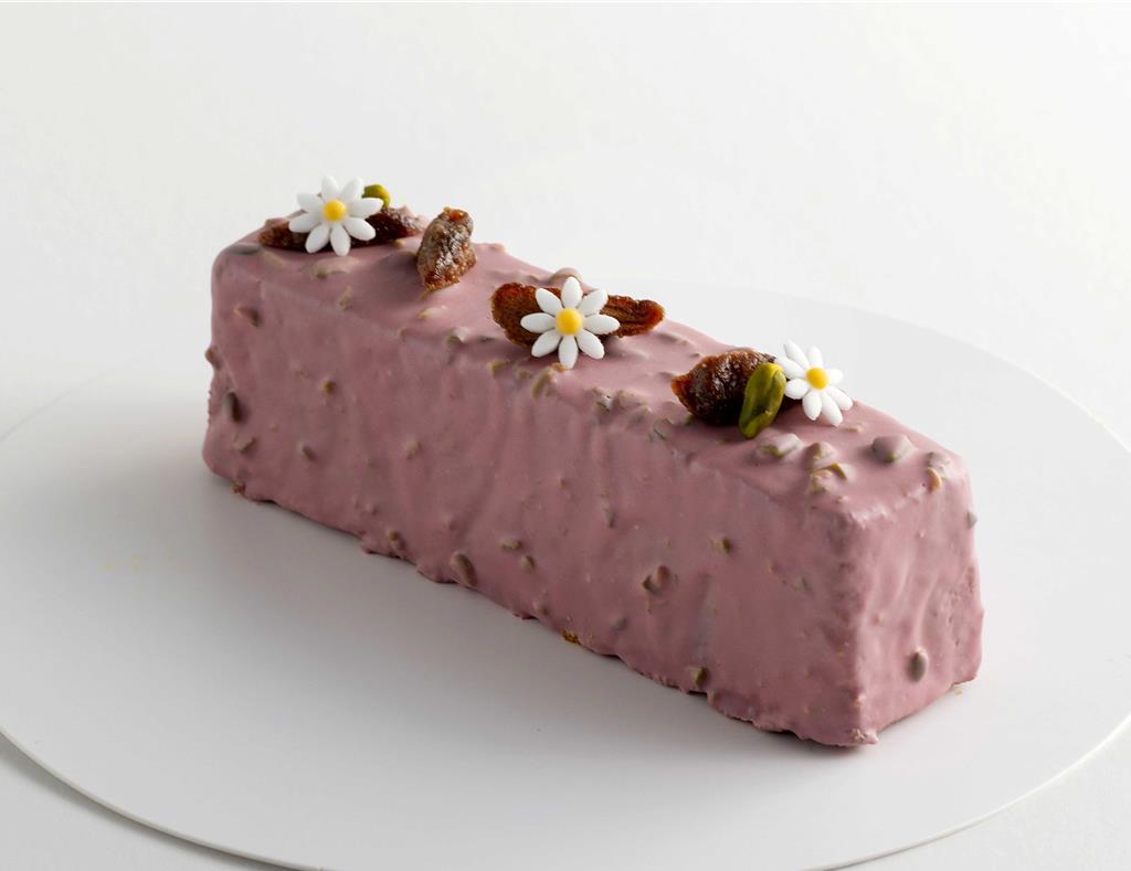 西山未來為〈島語自助餐廳〉設計的〈開心果草莓蛋糕〉，草莓蛋糕內餡擠入草莓杏桃醬、外層刷上草莓酒糖水，最後淋上開心果草莓巧克力淋面，是秋冬最應景的享受。圖／漢來美食提供