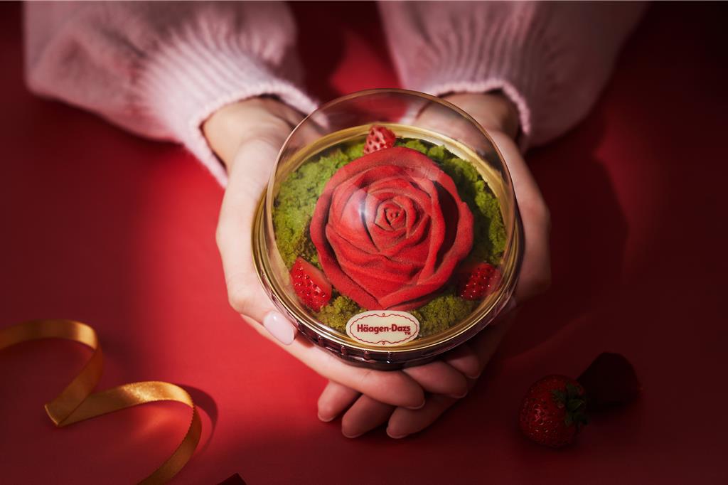 外包裝提盒以酒紅色為底，金線勾勒簡約玫瑰造型與形似花瓣的愛心圖案，透明的愛心還可以見到玫瑰嬌豔欲滴的模樣，兼顧質感與浪漫。(哈根達斯提供)
