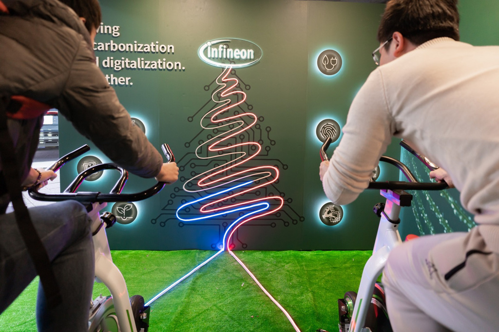現場民眾體驗「轉動永續、 騎向綠色未來」趣味遊戲，藉由踩踏單車發電，點亮象徵美好未來的霓虹聖誕樹。圖/英飛凌提供