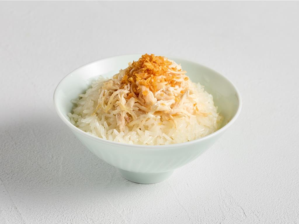 〈蒜味雞絲香米飯〉是在白飯澆上蒜油與蒜酥，搭配手切舒肥雞絲，噴香油潤。 新加坡樂天餐飲集團提供