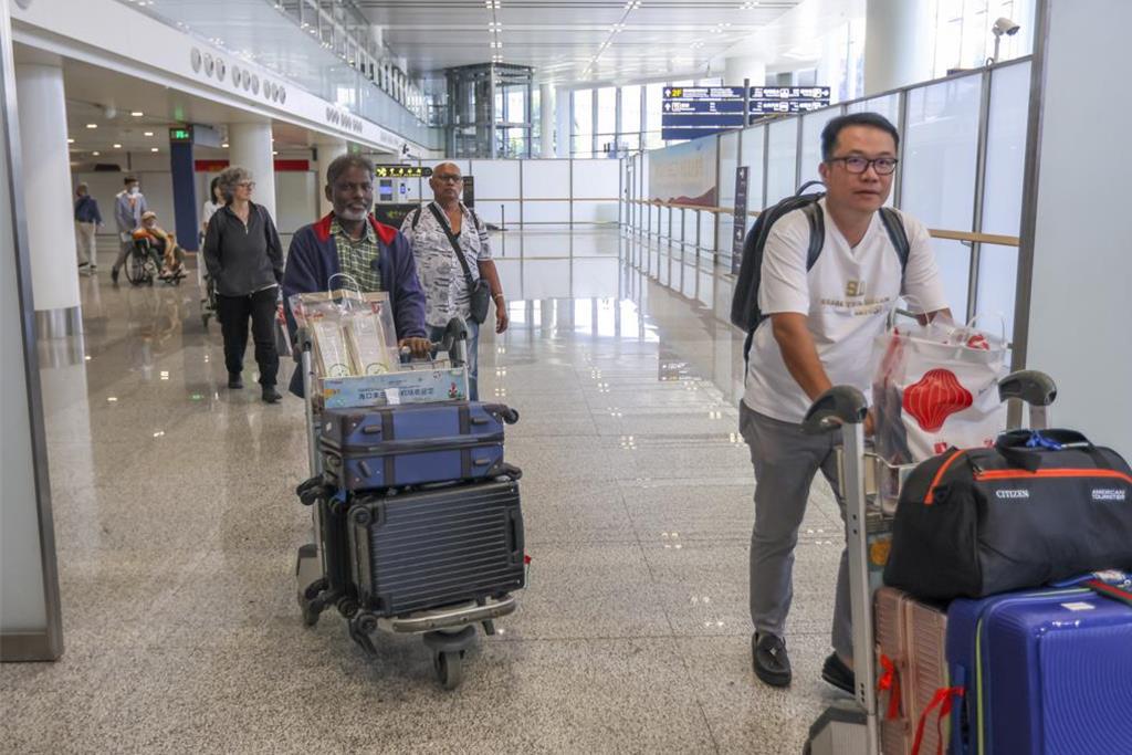 圖為11日的海口美蘭國際機場，來自新加坡的旅客走出國際到達區。（中新社資料照片）